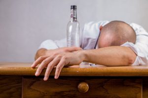 Discouraged man with an empty liquor bottle in his hand.